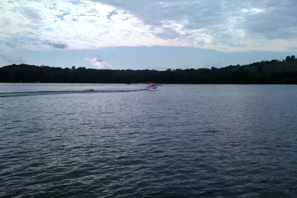Crystal Lake and its wooded shoreline under a cloudy sky in Burnsville, Minnesota